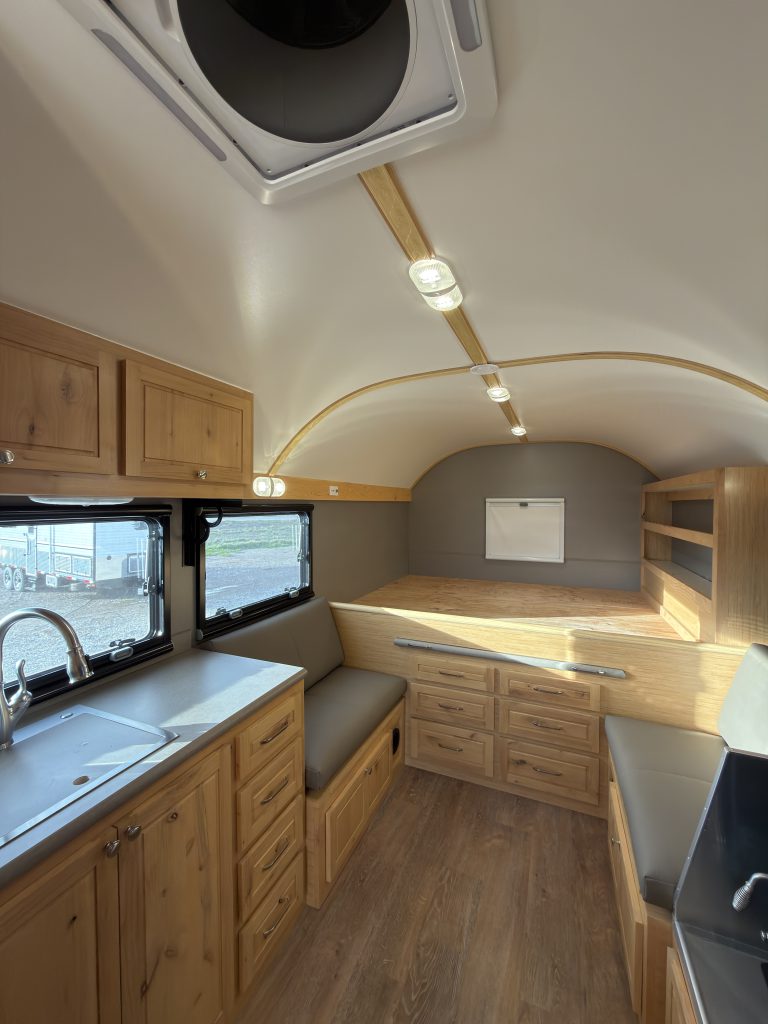Van Niewkoop Camp #136: Kitchen with hardwood cabinetry beside the raised east/west California king bed platform.