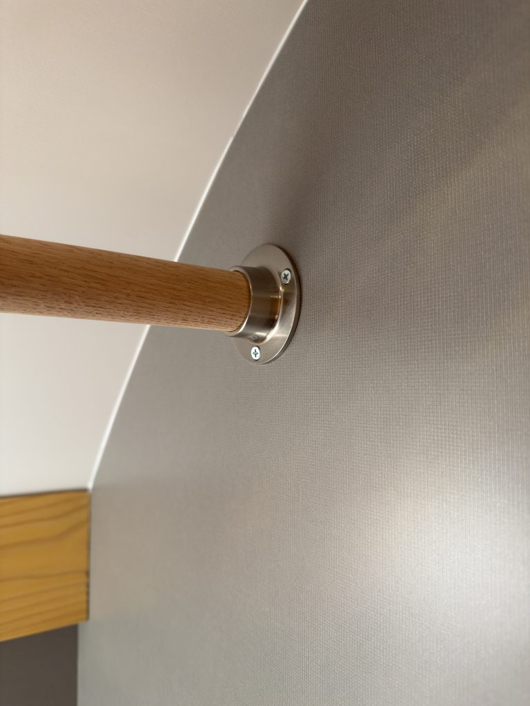 Close view of the closet hanging rod and wall mount in Van Niewkoop Camp #136.