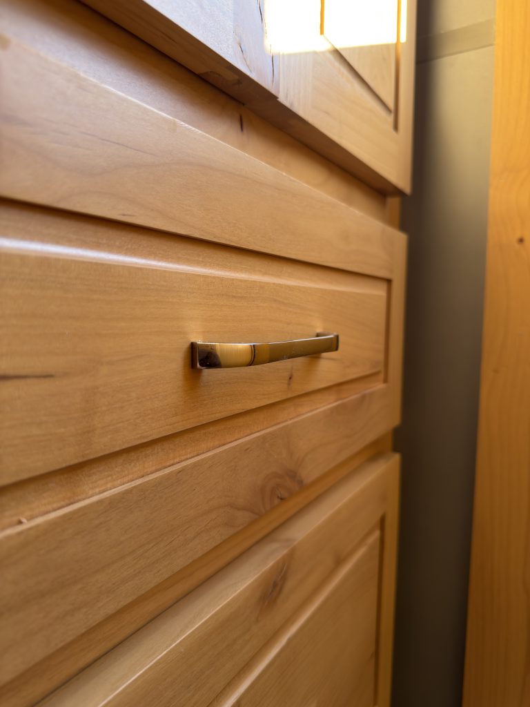 Van Niewkoop Camp #136: Close view of a brushed nickel bar-style pull on a hardwood drawer front.