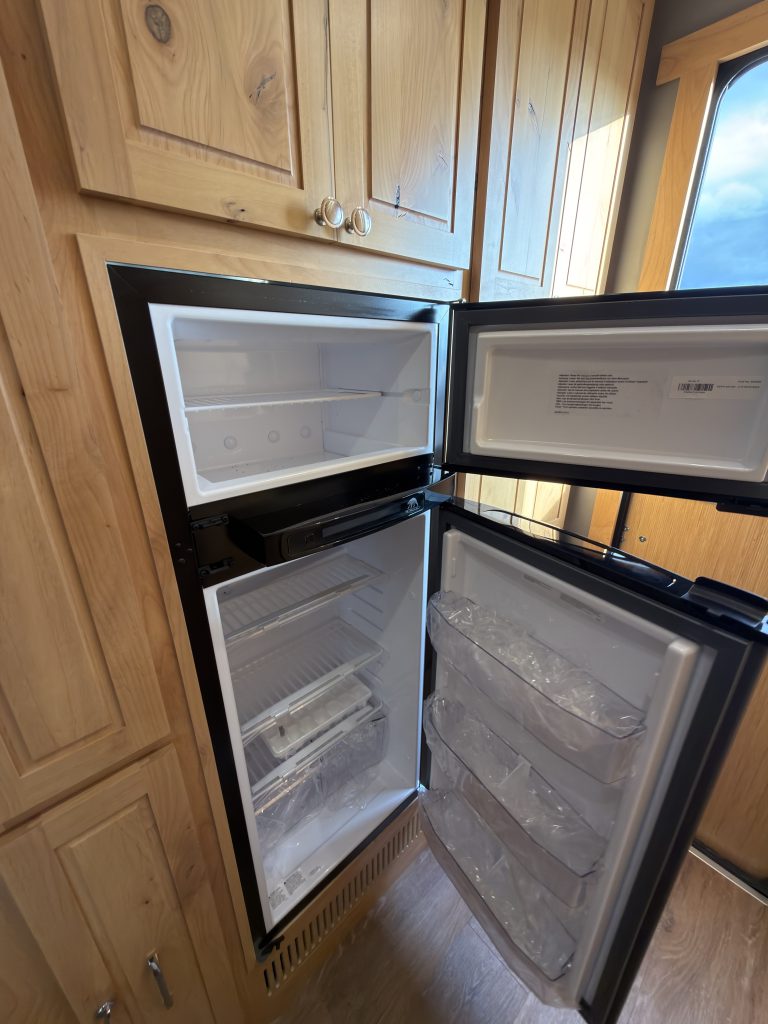 Van Niewkoop Camp #136: Norcold fridge-freezer with both doors open to show its shelves and compartments.