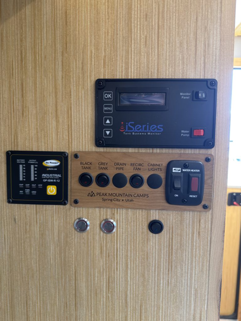 Van Niewkoop Camp #136: Close view of the tank-monitoring display and interior control switches above the kitchen counter.