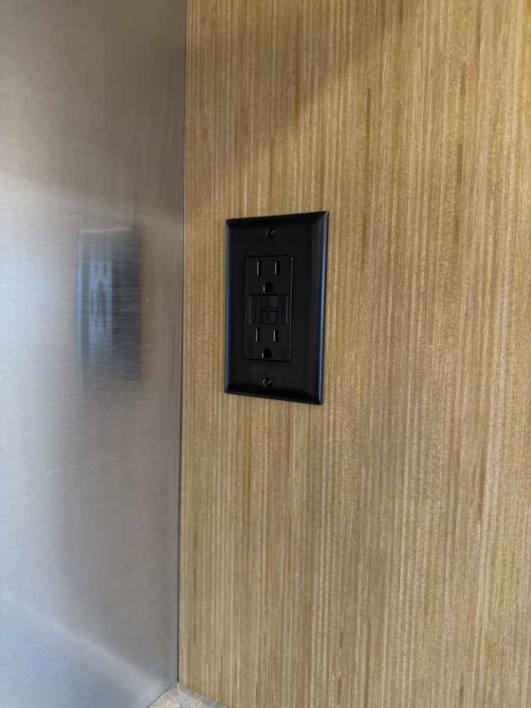 Black switch panel mounted on the wood interior wall in Van Niewkoop Camp #136.