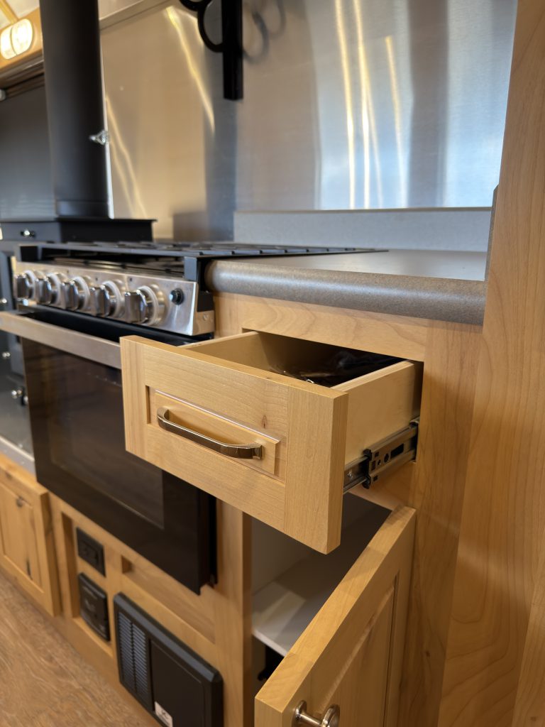 Open drawer above a lower kitchen cabinet in Van Niewkoop Camp #136.