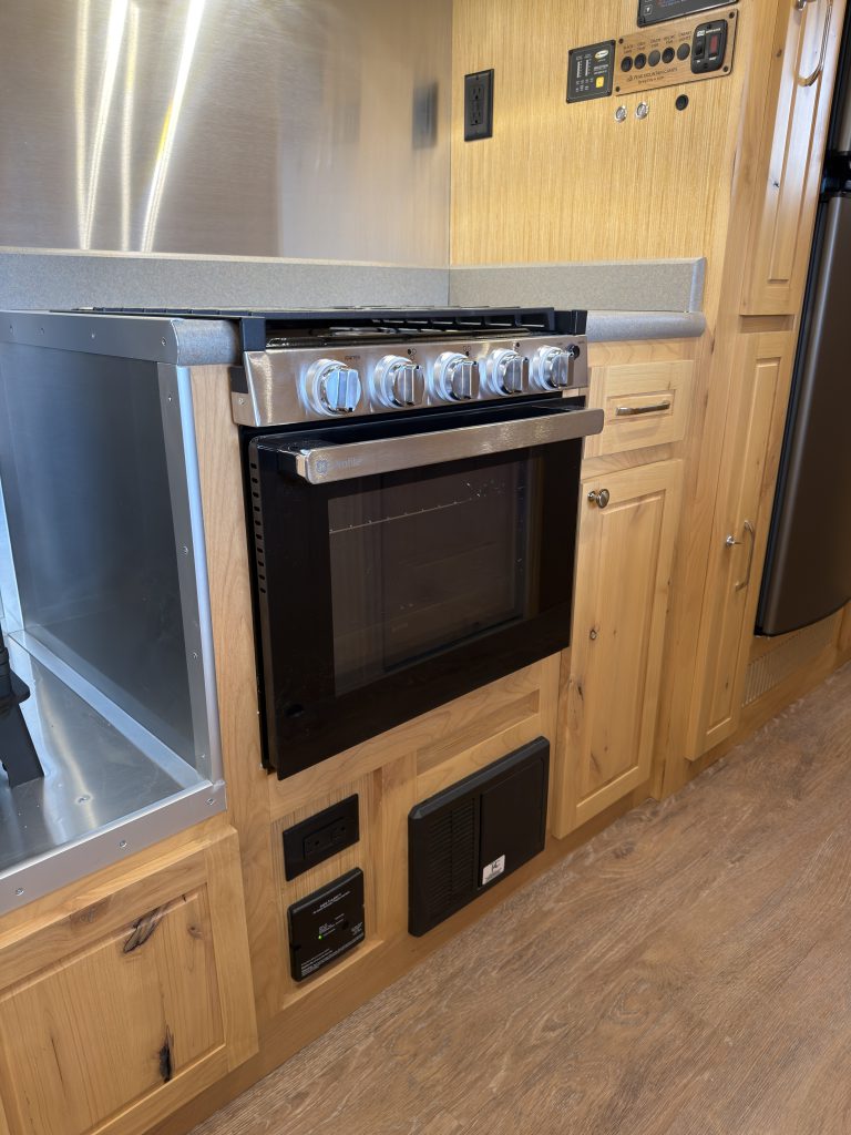 Van Niewkoop Camp #136: GE oven above the lower electrical panels and hardwood cabinetry.