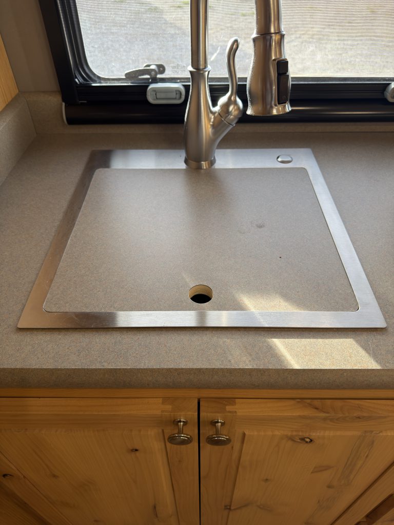 Van Niewkoop Camp #136: Single stainless steel kitchen sink with a fitted countertop cut-out and residential-style faucet.