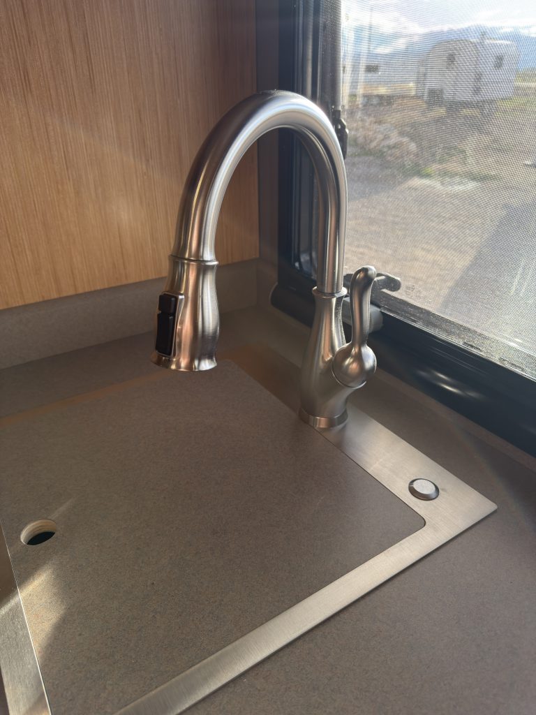 Van Niewkoop Camp #136: Close view of the residential-grade kitchen faucet above the stainless steel sink.