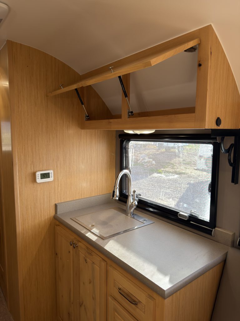 Van Niewkoop Camp #136: Upper cabinet above the sink opened and supported by a gas strut.