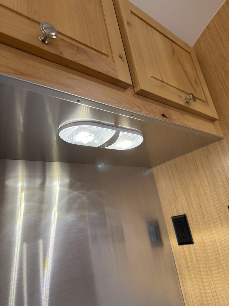 Van Niewkoop Camp #136: LED task light beneath the kitchen cabinet above the metal backsplash.