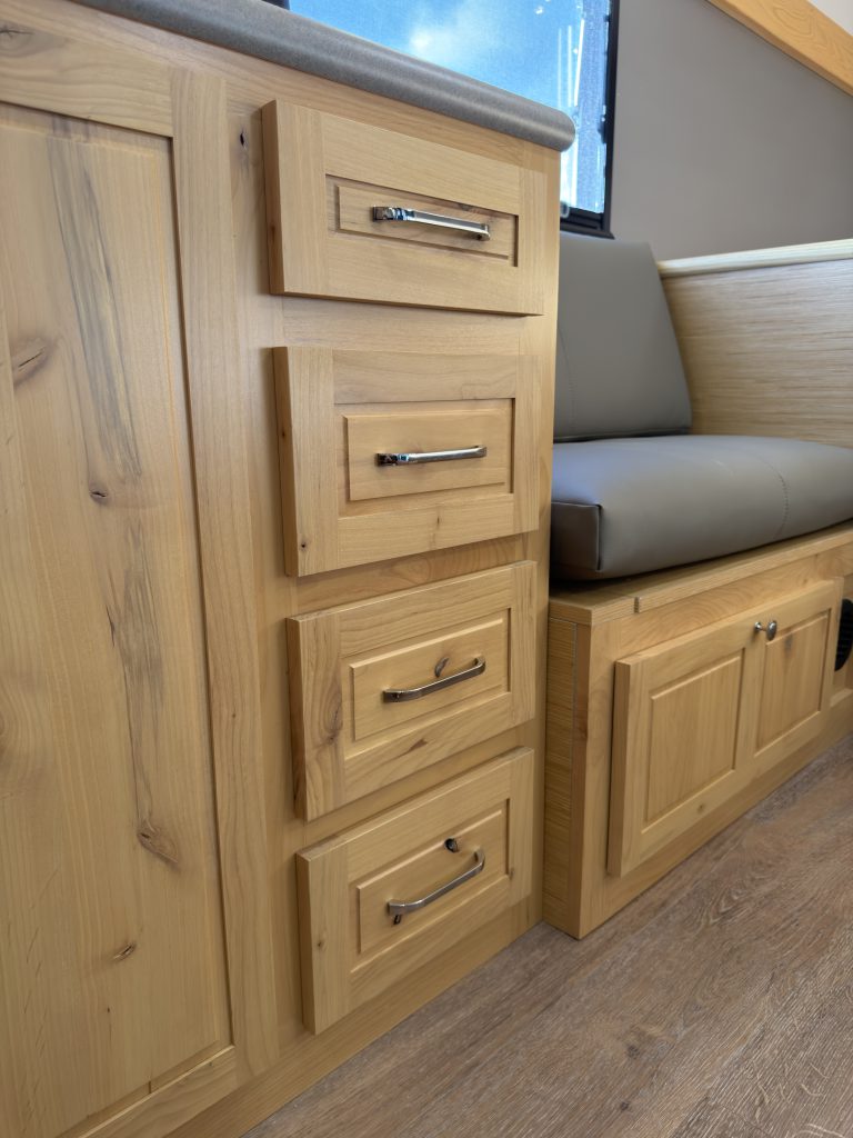Van Niewkoop Camp #136: hardwood drawer stack between the kitchen counter and upholstered side bench.