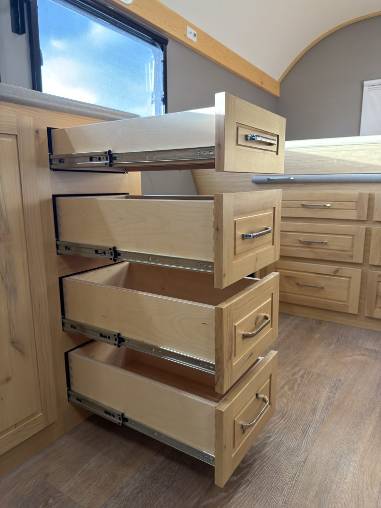 Van Niewkoop Camp #136: Kitchen drawers extended beside the bench, exposing their metal slides and wood drawer boxes.