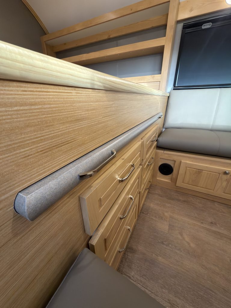 Van Niewkoop Camp #136: Close view of the long handle on the pull-out table beneath the bed.