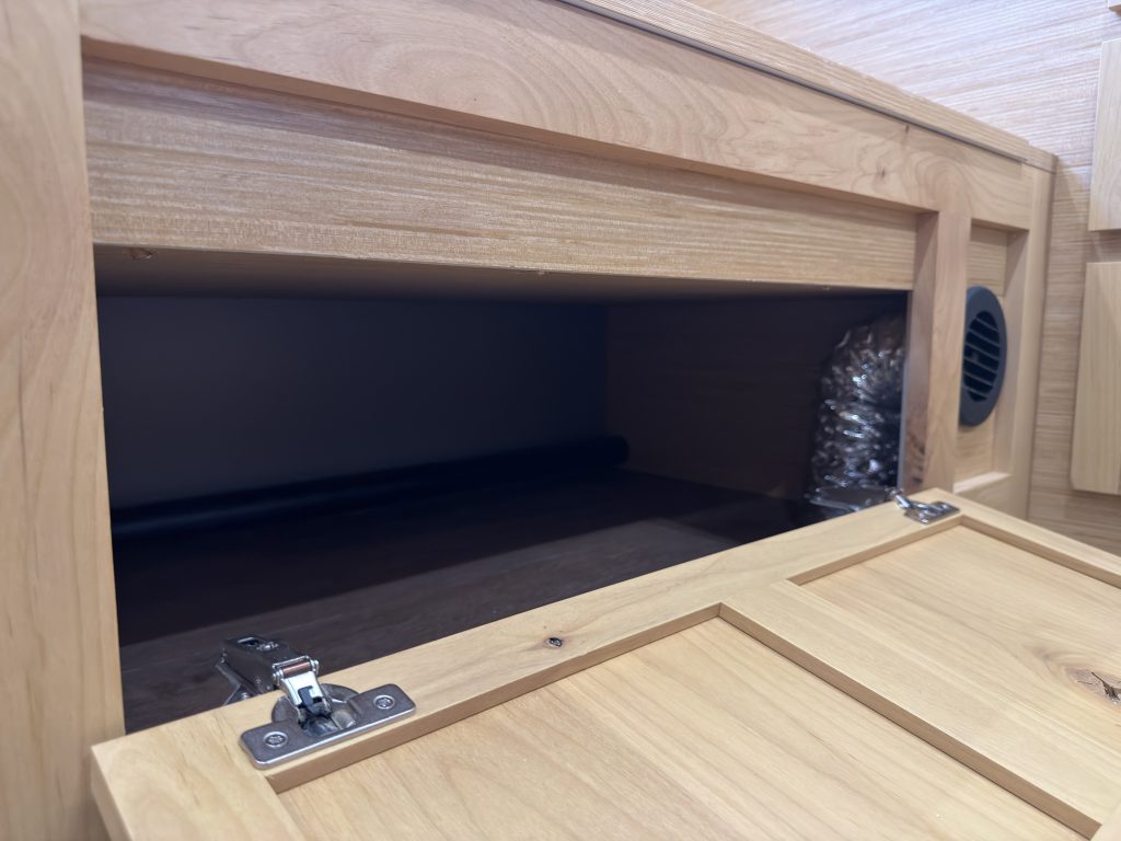 Van Niewkoop Camp #136: Open cabinet storage beneath the wood bench seat.