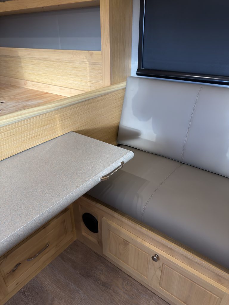 Van Niewkoop Camp #136: Corner view of the pull-out dinette table and upholstered side bench.