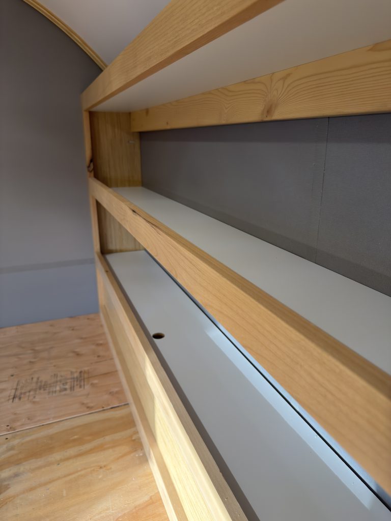 Van Niewkoop Camp #136: Recessed roadside headboard bookshelf along the raised bed platform.