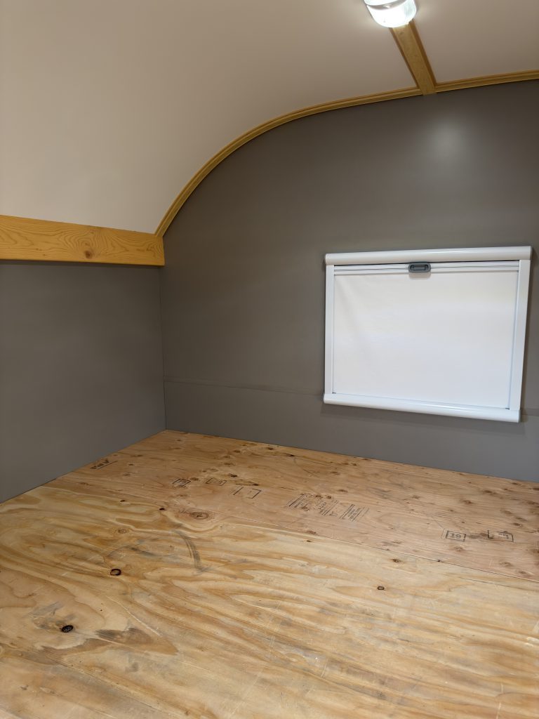 Van Niewkoop Camp #136: Rear California king bed platform beneath the lowered integrated blackout blind.