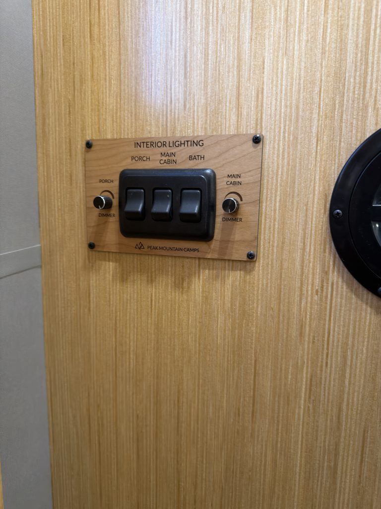 Close view of the interior switch bank on the wood wall in Van Niewkoop Camp #136.