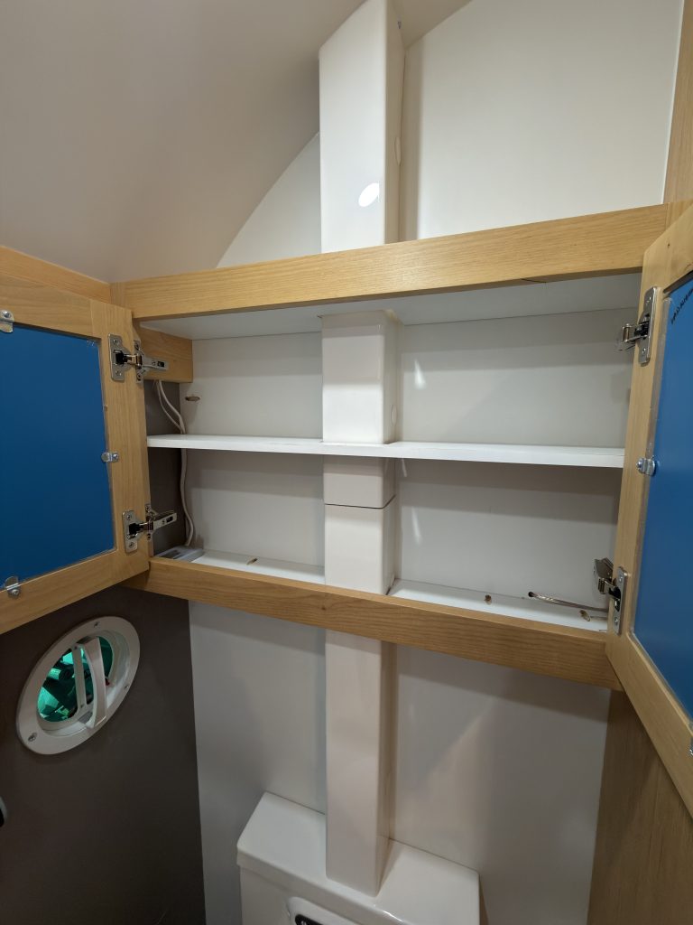 Van Niewkoop Camp #136: Mirrored medicine cabinet opened to show its storage shelves.