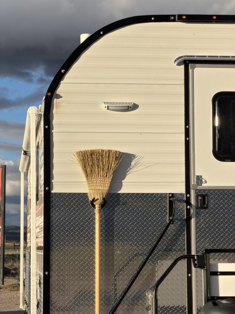 Van Niewkoop Camp #136: Close view of the front wall, Dutch entry door, and secured corn broom.