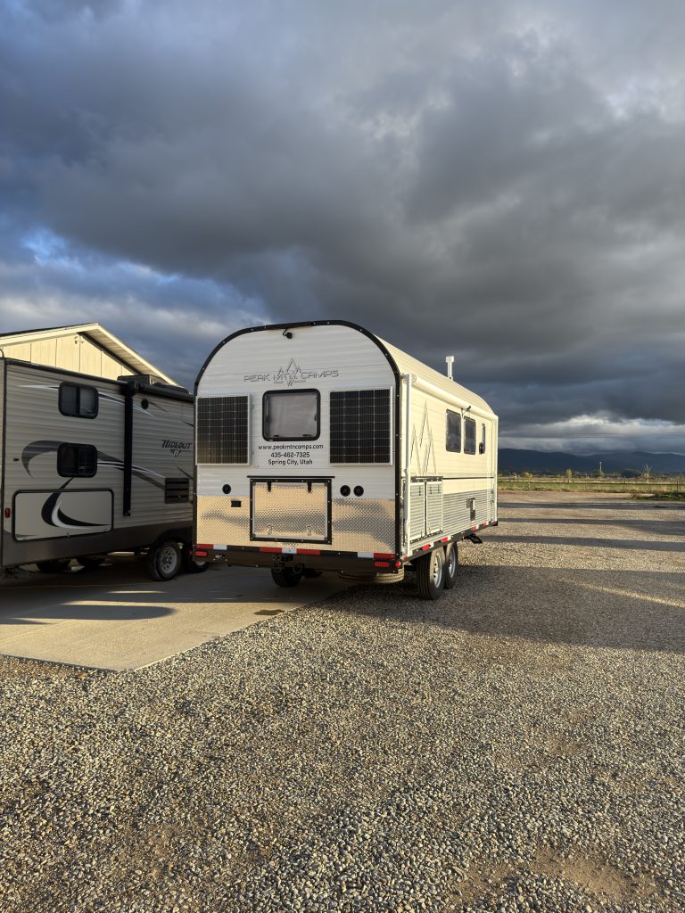 Wide rear exterior view in the gravel lot in Van Niewkoop Camp #136.