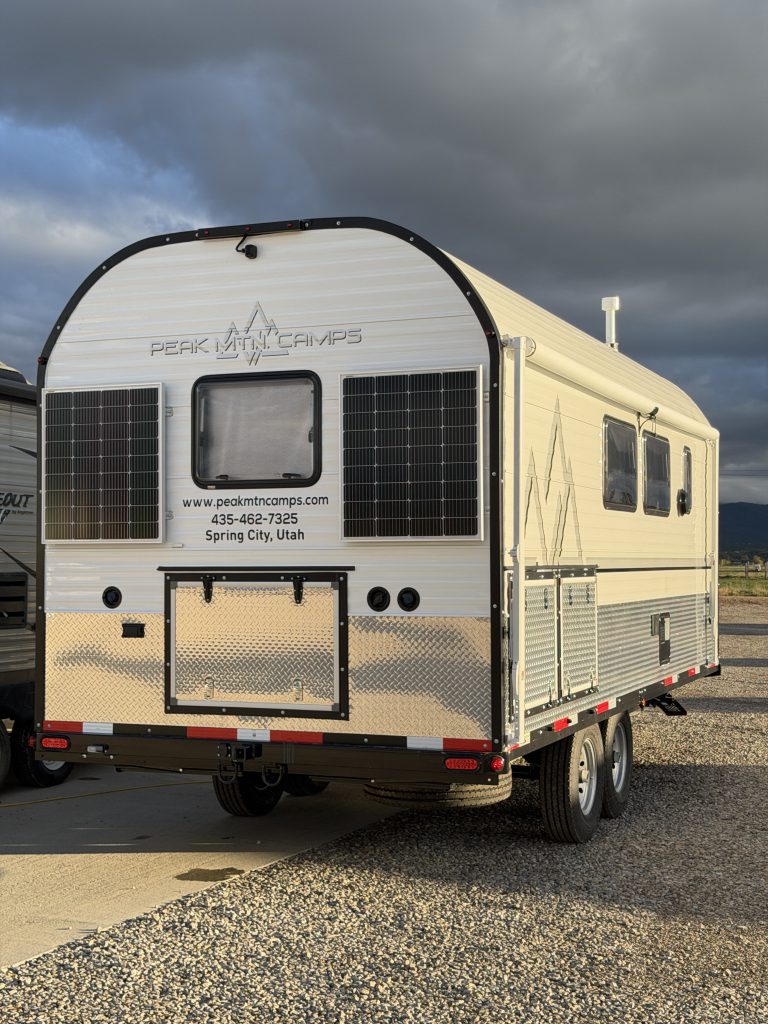 Van Niewkoop Camp #136: Rear exterior with two 100-watt solar panels, the egress window, and lower water-system storage hatch.
