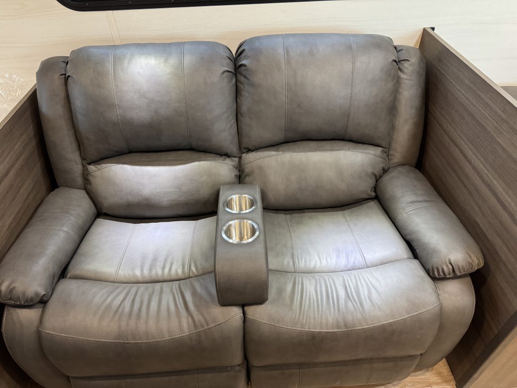 Two cushioned reclining seats with a shared center armrest and cup holders in Watson Camp #134.