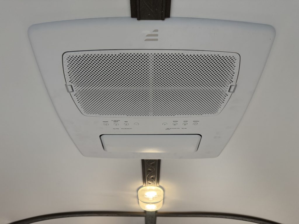 Ceiling-mounted air conditioner beside rosewood ceiling trim and a light in Watson Camp #134.