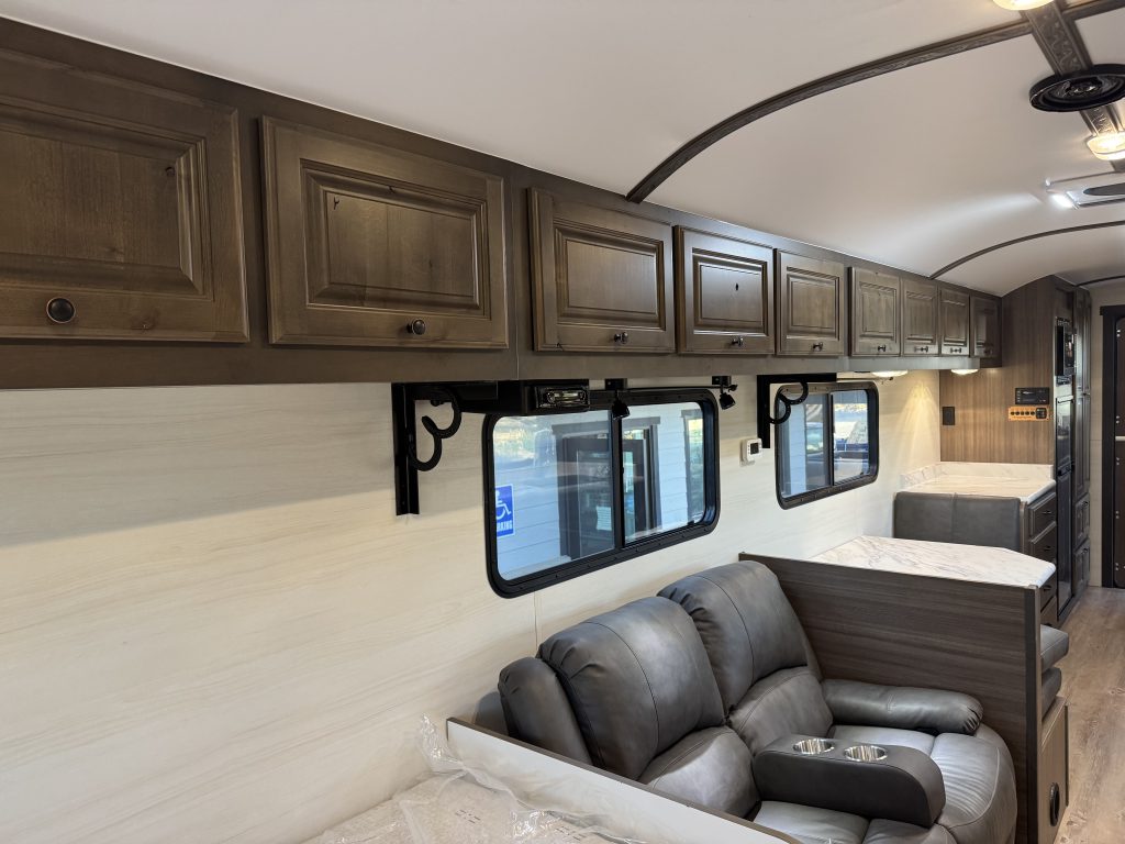 Reclining seats beneath windows and overhead cabinets, with a table beyond in Watson Camp #134.