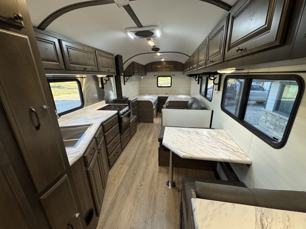 Interior showing kitchen cabinets on the left and a single dining table with bench seating on the right in Watson Camp #134.